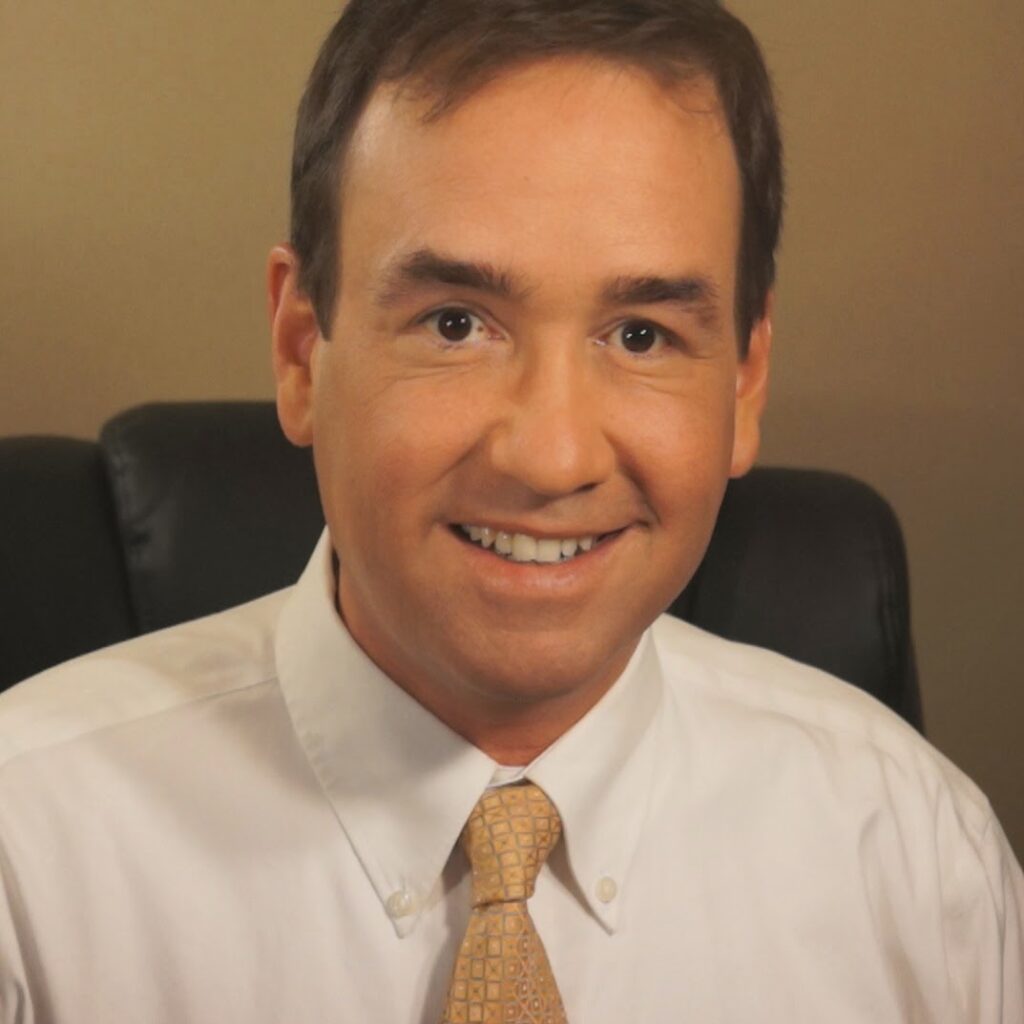 headshot photo of Strasburg, Va resident and site owner Dan McDermott in a white shirt and yellow tie.