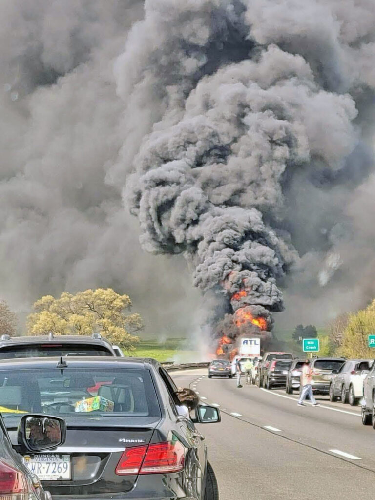 A tractor-trailer engulfed in flames after jackknifing on Interstate 81 in Shenandoah County, Virginia. Smoke billows from the wreckage as fire crews respond.